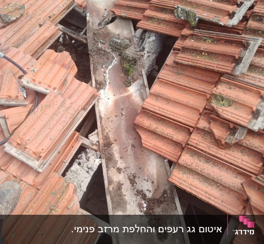 רעפים שבורים על גג עם תעלה חלודה